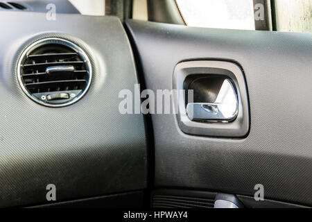 Detail of new modern car interior, Focus on heating ventilation system and door handle Stock Photo