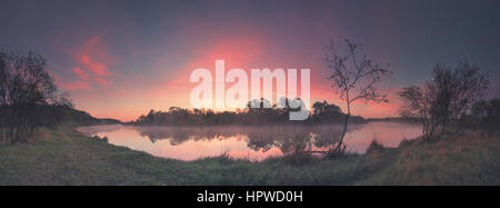 Summer misty morning with rising sun shining on clouds Stock Photo