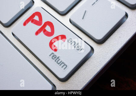 Word PPC (pay per click) written on a keyboard. Stock Photo