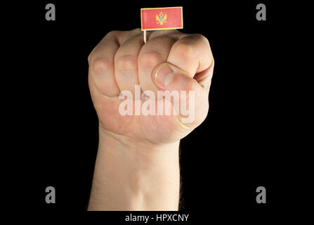 Man hand fist with Montenegrin flag isolated on black background Stock Photo