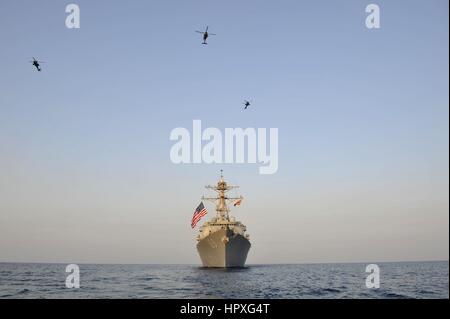 SH-60B Sea Hawk helicopter from Proud Warriors of Helicopter Anti-submarine Squadron Light (HSL) 42, Det, 2012. 7 and helicopters from U.S. Army 35th Combat Aviation Brigade fly in formation over guided-missile destroyer USS Jason Dunham (DDG 109) after US Army-Navy interoperability training. Image courtesy Devin B. King/US Navy. Stock Photo