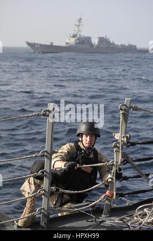 Logistics specialist Brandon Highwood boards a guided-missile destroyer USS Jason Dunham during an exercise for the visit, board, search, and seizure team, January 16, 2013. Image courtesy US Navy. Stock Photo