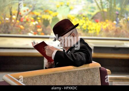 Man in Derby Hat reading Stock Photo