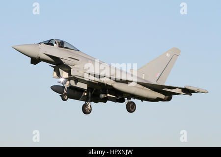 RAF Typhoon landing at RAF Coningsby in clear skies. Note the lucky strobe light catch under the air intake. Stock Photo