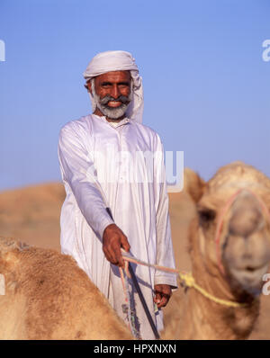 Smiling camel driver with camel, Dubai Desert, Dubai, United Arab Emirates Stock Photo