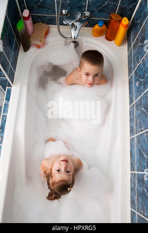 Brother and sister taking a bubble bath. Little boy and girl playing ...