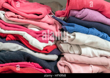 A stack of knitted warm woolen clothes in wardrobe close up Stock Photo