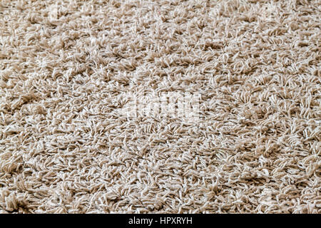 Light yellow shaggy carpet sample, a closeup shot of rug background texture. Knitted fabric Stock Photo