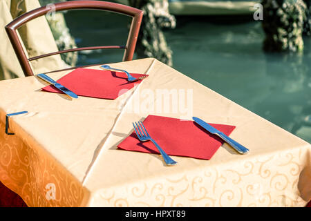 Table setting with stack of plates and cutlery . Stock Photo