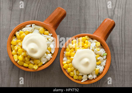 Rice salad and canned corn with mayonnaise, on a gray wooden background. Stock Photo