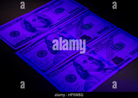 Three hundred dollar bills under ultraviolet light. Stock Photo
