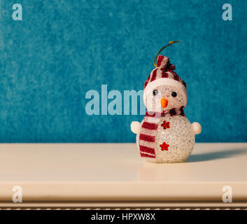 Toy snowman on a blue background. There is a place for the text. Stock Photo