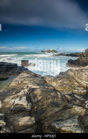 The lighthouse at Gwithian, in West Cornwall with rocks in the foreground Stock Photo