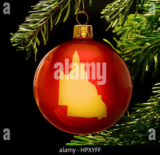A red bauble with the golden shape of  Queensland hanging on a christmas tree isolated on black.(series) Stock Photo