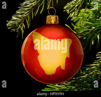 A red bauble with the golden shape of  Tasmania hanging on a christmas tree isolated on black.(series) Stock Photo