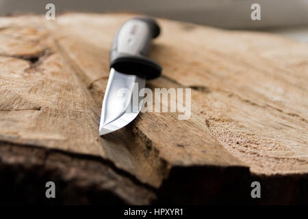 Carving knife side view. Knife on a wooden background. Stock Photo