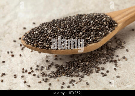 Wooden spoon with raw chia seeds Stock Photo