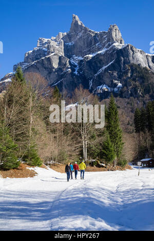 Walkers in Reserve Naturelle de Sixt Fer A Cheval below Pic de Tenneverge in Le massif du Giffre in French Alps in winter. Samoens Haute Savoie France Stock Photo