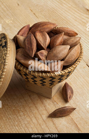 Unshelled pili nuts from the Philippines in a asian basket Stock Photo