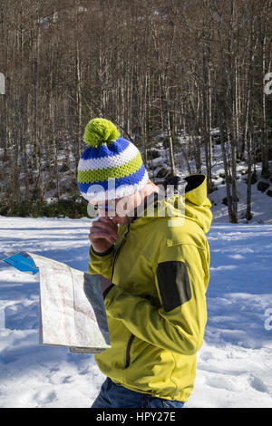 Man looking at a map in Reserve Naturelle de Sixt Fer A Cheval in Le massif du Giffre in French Alps. Samoens Haute Savoie Rhone-Alpes France Stock Photo