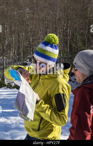 Men looking at a hiking map in Reserve Naturelle de Sixt Fer A Cheval in Le massif du Giffre in French Alps. Samoens Haute Savoie Rhone-Alpes France Stock Photo