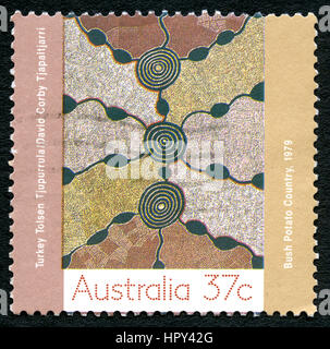 AUSTRALIA - CIRCA 1979: A used postage stamp from Australia, depicting aborginal artwork entitled Bush Potato Country, circa 1979. Stock Photo