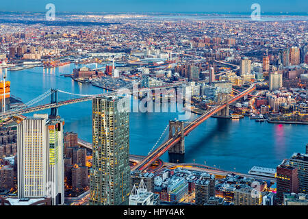 Brooklyn and Manhattan bridges span East River at dusk, between Manhattan island and Brooklyn borough Stock Photo