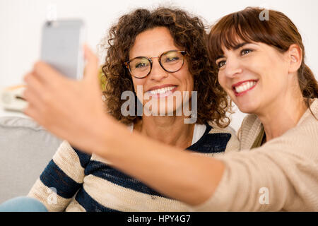 Two beautiful firends at home making  a selfie Stock Photo