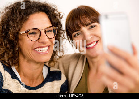 Two beautiful firends at home making  a selfie Stock Photo