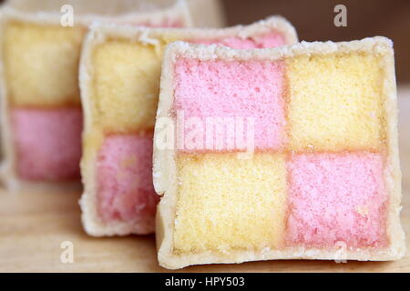 Freshly cut Battenberg Cake slices with pink and yellow sponge covered in marzipan Stock Photo