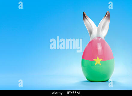 Colorful cute ceramic easter egg with rabbit ears and the flag of Burkina Faso .(series) Stock Photo