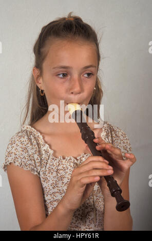young girl playing recorder Stock Photo