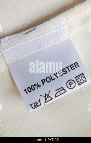 100% polyester label in woman's blouse with care washing instructions symbols Stock Photo