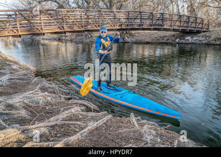 Stand up paddling on the Poudre RIver - a summer day like day in the middle of winter in northern Colorado Stock Photo