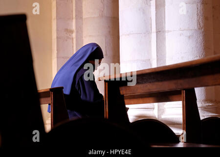 A Catholic nun prays inside the church owned by the Armenian Catholics called “Our Lady of the Spasm.” at the 4th station of the cross marking the place where Jesus met his mother, the Virgin Mary, also known as Saint Maria in Via Dolorosa street Old City East Jerusalem Israel Stock Photo