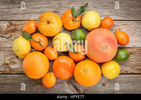 citrus fruit collection (orange, lemon, lime, grapefruit, tangerine, mandarin, kumquat) on weathered rustic wood, top view Stock Photo