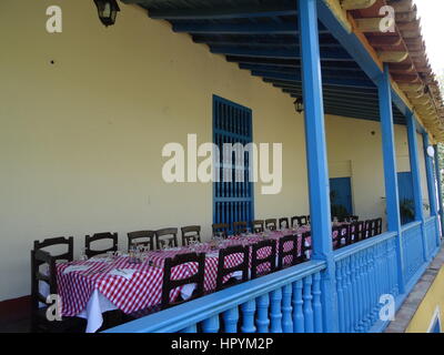 Blue wooden veranda with long set up table in a sugar cane plantation hacienda, Valley de los Ingenios, Cuba Stock Photo