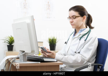 Portrait of a female doctor using smartphone in her office Stock Photo
