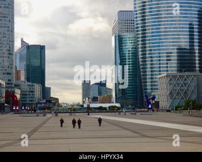 Four heavily-armed military personnel patrol the deserted esplanade at the Grande Arche at La Défense, early on a Sunday morning. Paris, France. Stock Photo