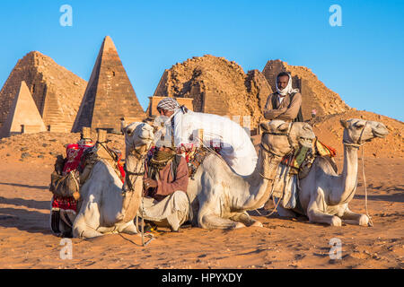 Khartoum, Sudan - Dec 19, 2015: Cameleer posing with his camel at sunrise ahead of the pyramids. Stock Photo