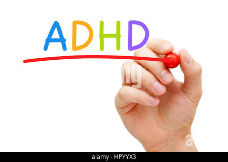 Hand writing ADHD Attention Deficit Hyperactivity Disorder with marker on transparent glass board. Stock Photo