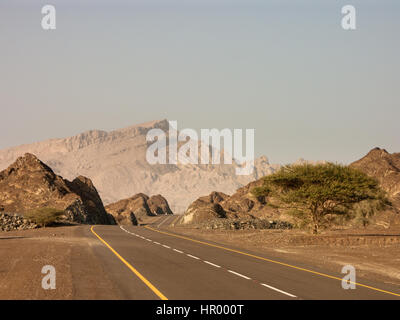 winding road leading toward mountain disapperaring in distance Stock Photo