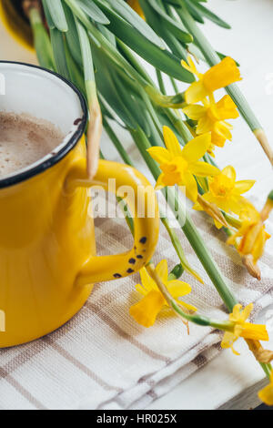 Spring flowers daffodils with a cup of coffee, cappuccino and close-up Stock Photo