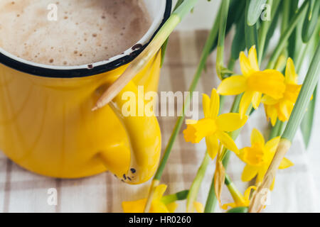 Spring flowers daffodils with a cup of coffee, cappuccino and close-up Stock Photo