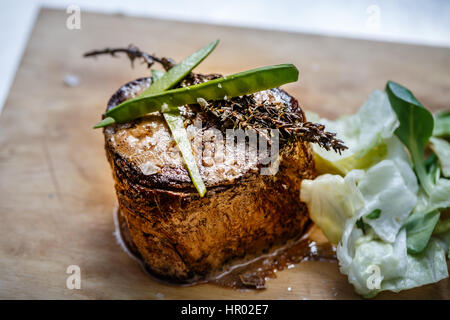 Medium roast rib-eye steak served with lettuce Stock Photo