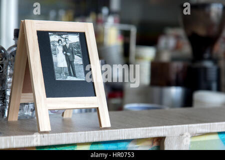 Old memorial picture of King and Queen of Thailand in frame on desk in the restaurant Stock Photo