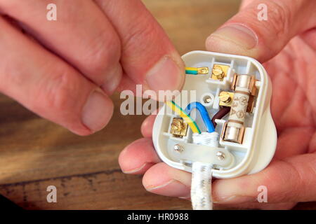 electrician rewiring a uk 13 amp domestic electric plug Stock Photo - Alamy