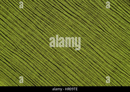 Light green crinkled fabric with irregular diagonal lines textile abstract background texture Stock Photo