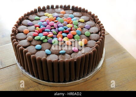 Chocolate cake covered in chocolate fingers, chocolate buttons and chocolate beans Stock Photo