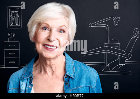 Healthy teeth. Positive nice delighted woman standing in the dentist office and smiling while having a dentist check up Stock Photo